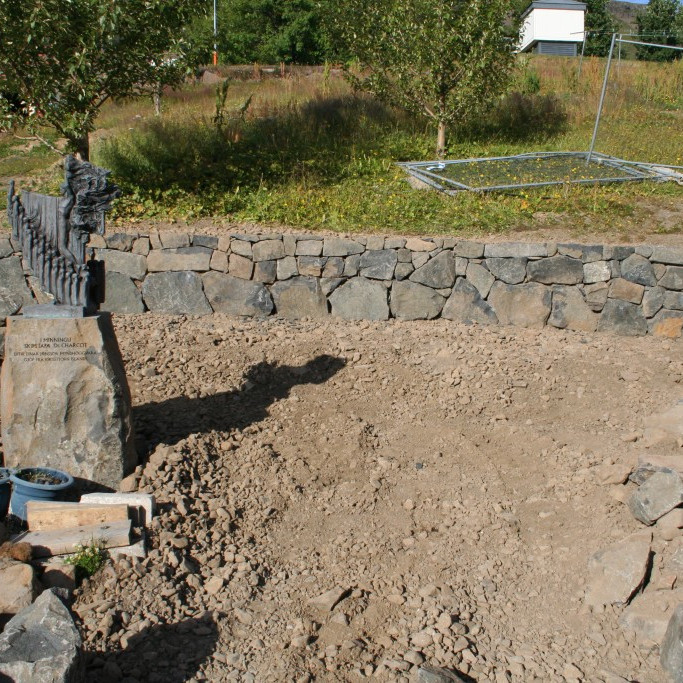 Hlaðinn steinveggur sem liggur fyrir aftan Læknishúsið